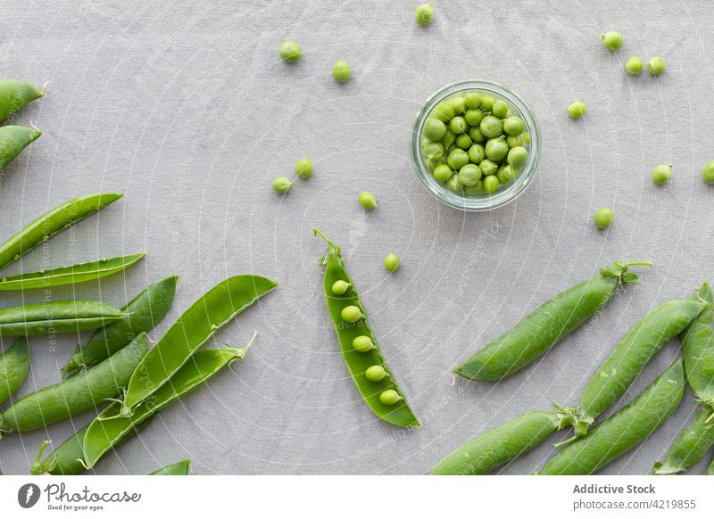 Bowl with heap of pea pods and green peas bowl fresh crunchy vegetarian raw healthy bean nutrient glass crispy uncooked vitamin whole table edible organic