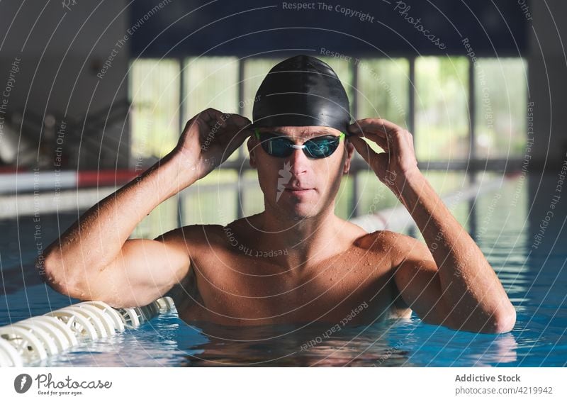 Swimmer in goggles during workout in pool swimmer sport training muscular masculine naked torso man portrait practice body wellness fit professional water
