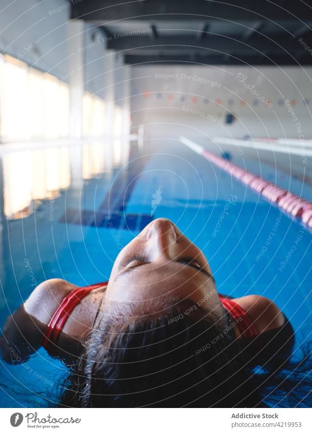 Sportswoman in swimsuit swimming in pool with transparent water sportswoman wellness vitality energy feminine motion ripple swimwear athlete pure tile