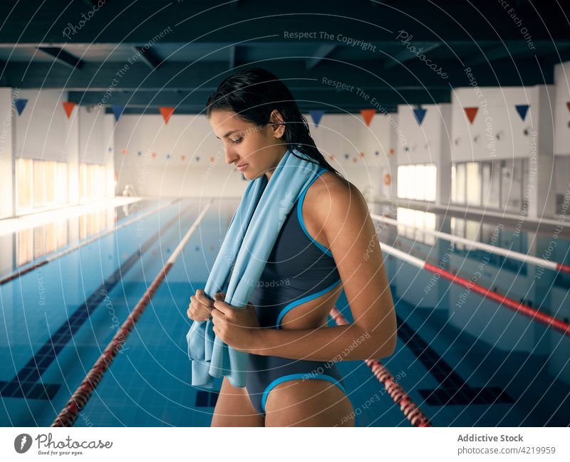 Swimmer in swimsuit against pool after working out swimmer towel wet hair sport body swimwear professional woman portrait wellness lane vitality charming
