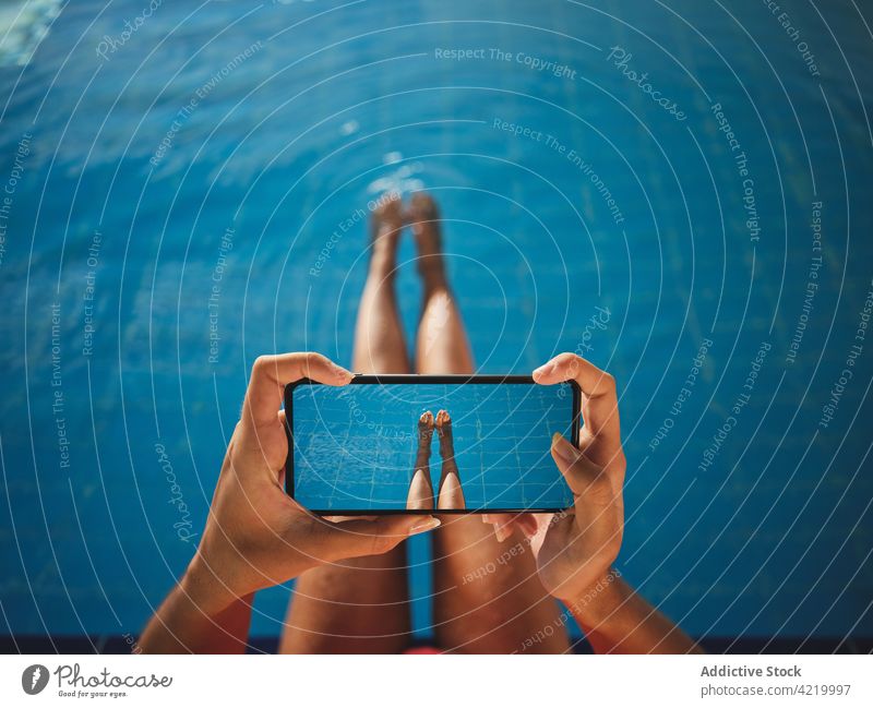 Crop woman taking photo on smartphone above swimming pool take photo leg moment memory screen using gadget device cellphone tile pure transparent water blue