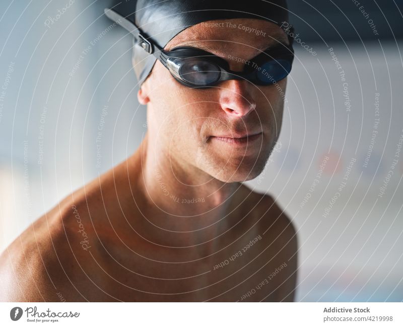 Determined sportsman in goggles during workout swimmer determine motivation training muscular portrait professional swimming cap serious confident bicep body