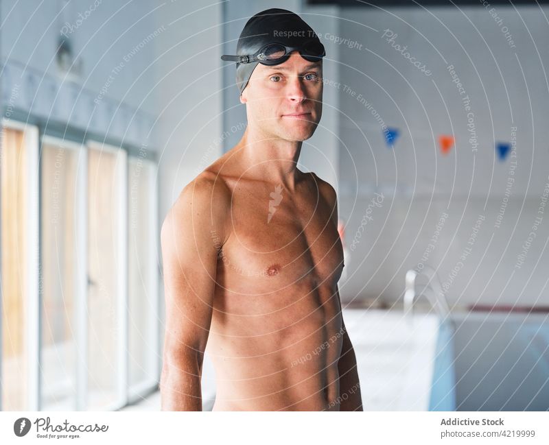 Determined sportsman in goggles during workout swimmer determine motivation training muscular portrait professional swimming cap serious confident bicep body