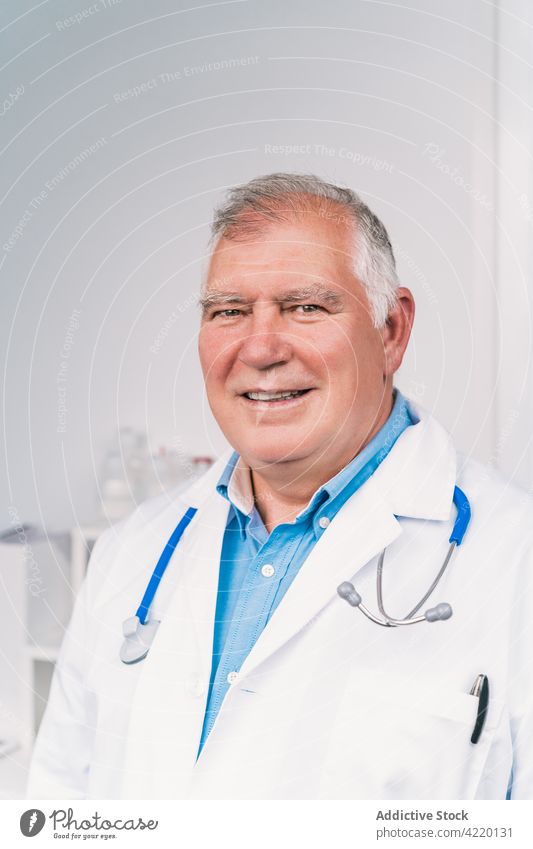 Smiling physician in medical uniform in clinic smile professional stethoscope friendly man portrait sincere content candid enjoy confident robe white color