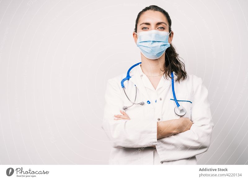 Confident physician in medical robe with crossed arms doctor arms crossed self assured uniform professional specialist protect health care woman portrait