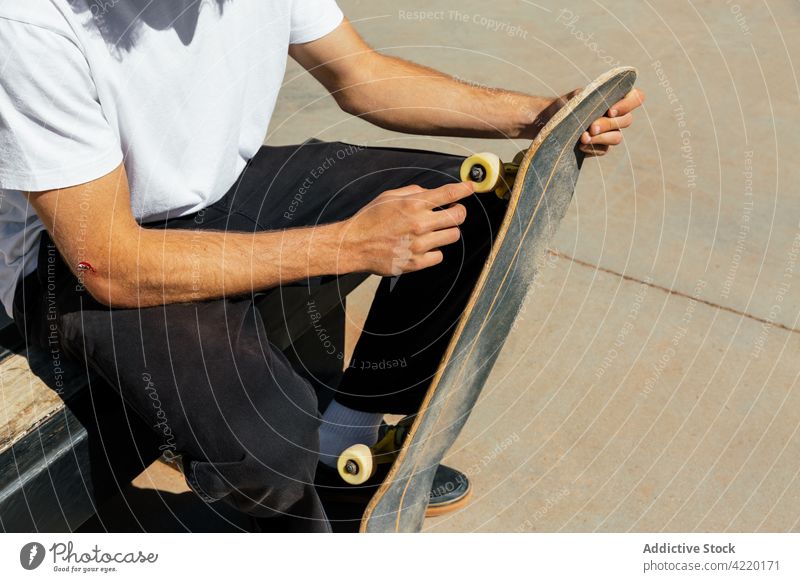 Man's hands with a scrape holding a skateboard Young man skating unrecognizable wheel skatepark skater sport concrete yellow style outdoor copy space active