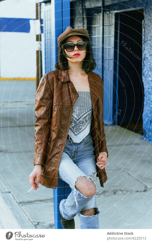 Stylish Asian model with cigarette on street fashion cool style hand on hip individuality street style woman portrait sunglasses millennial accessory red lips