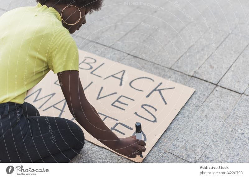 Black woman creating poster for Black Lives Matter protest black lives matter placard write activist racism discriminate protester female blm african american