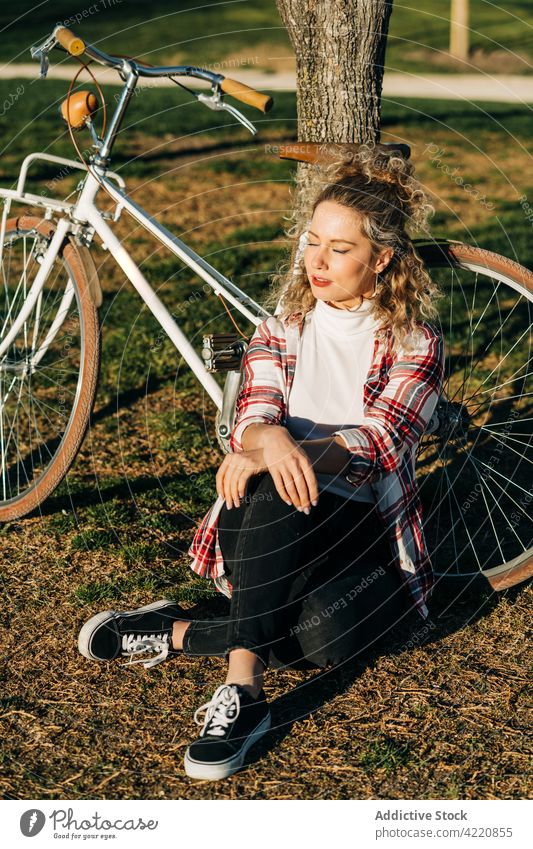 Carefree woman enjoying sunny day in park bicycle dreamy bike carefree garden summer female tree tranquil peaceful sit rest harmony charming calm serene lady