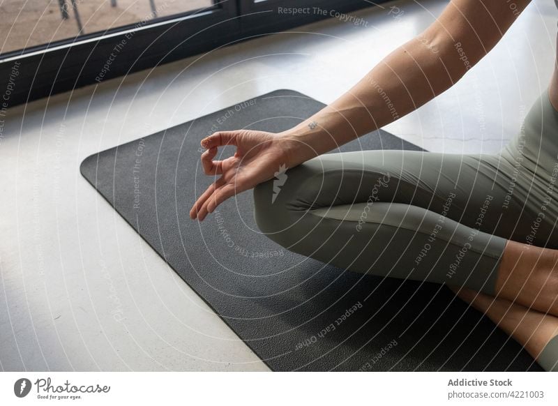 Crop mindful woman meditating in Half Lotus pose at home half lotus pose meditate yoga mudra stress relief concentrate spirit energy mat mindfulness serene