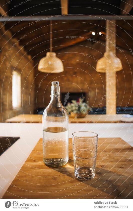 Glass and bottle of water on cutting board at home glass fresh pure natural transparent chopping board kitchen house wooden table material organic liquid