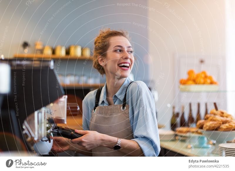 Female barista making coffee people woman young adult casual attractive female smiling happy indoors Caucasian toothy enjoying cafe restaurant apron business