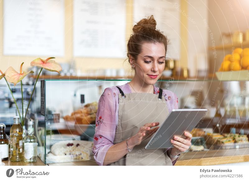 Young woman working in coffee shop people young adult casual attractive female smiling happy indoors Caucasian toothy enjoying cafe restaurant apron business