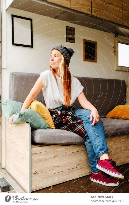 Content woman relaxing on sofa in van travel traveler truck lake hipster vacation thoughtful enjoy female sit rest holiday summer trip style pensive couch shore