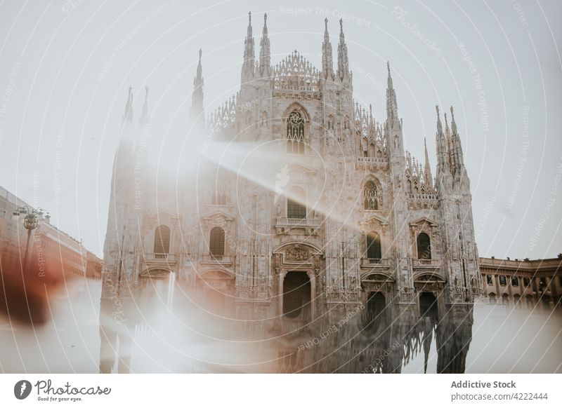 Aged cathedral with decoration in sunshine in town architecture reflection sacred religion catholic magnificent city duomo facade majestic sunbeam urban