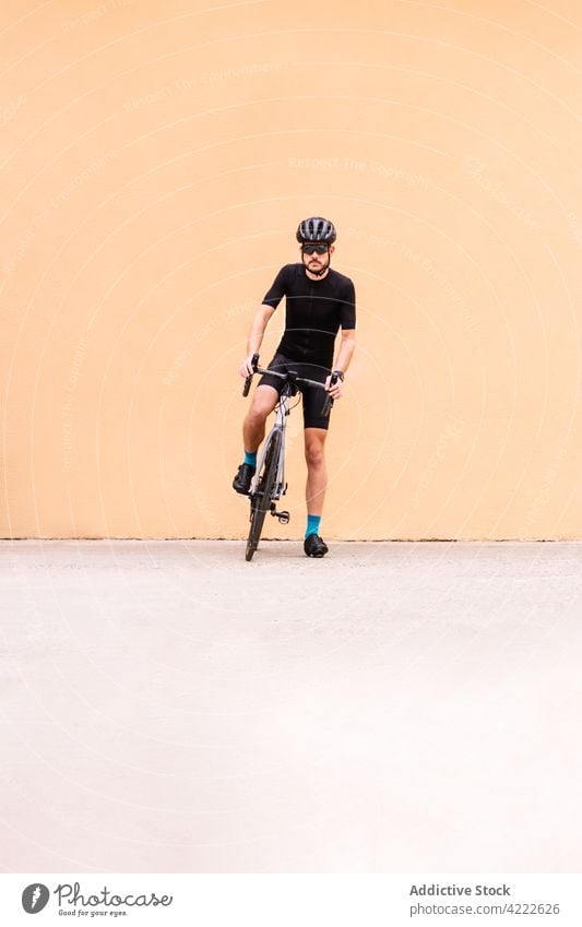 Cyclist with bicycle walking on urban pavement bicyclist bike sport professional style masculine man transport vehicle sock helmet sunglasses modern macho town