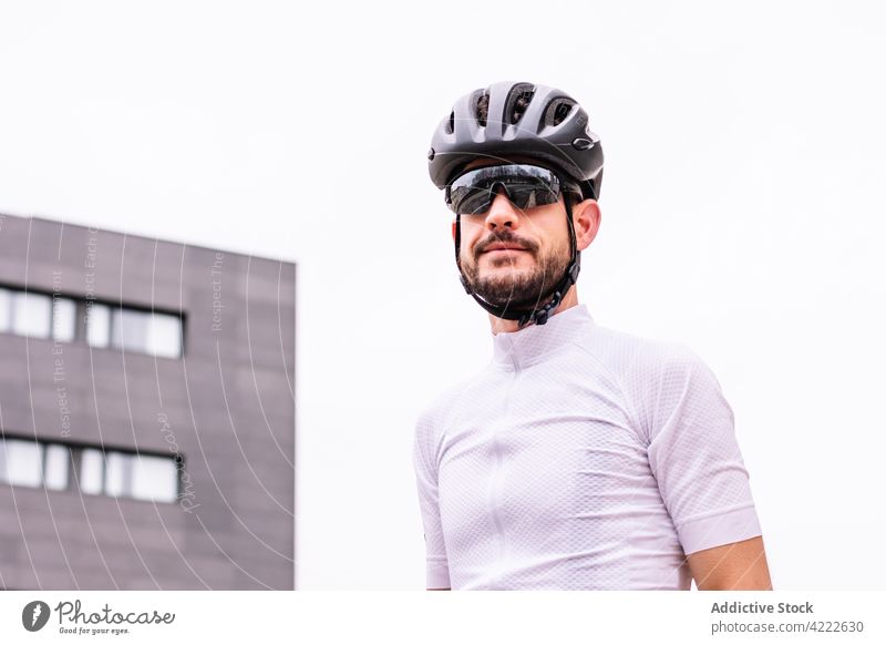 Cyclist in protective helmet and sports t shirt in town cyclist sunglasses style professional modern masculine macho man brutal building sportsman virile