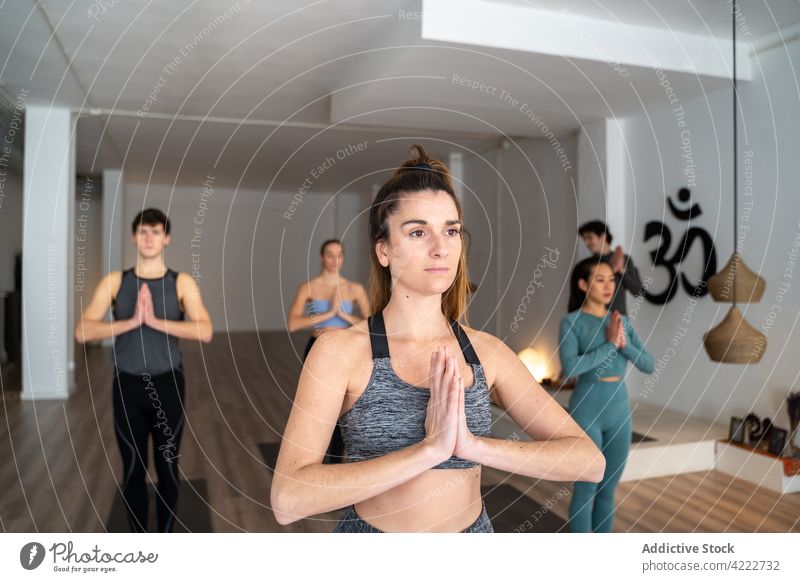 Woman practicing yoga during group lesson in studio class woman practice people together mountain pose wellness asana calm zen energy sportswear harmony healthy