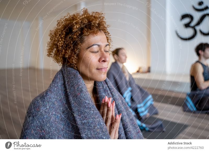 Ethnic woman meditating during group yoga lesson meditate class together people namaste zen mindfulness multiethnic multiracial diverse wellness relax healthy