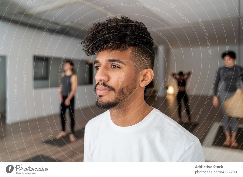 Black man standing in yoga studio during lesson class group together practice company concentrate multiracial multiethnic diverse black african american