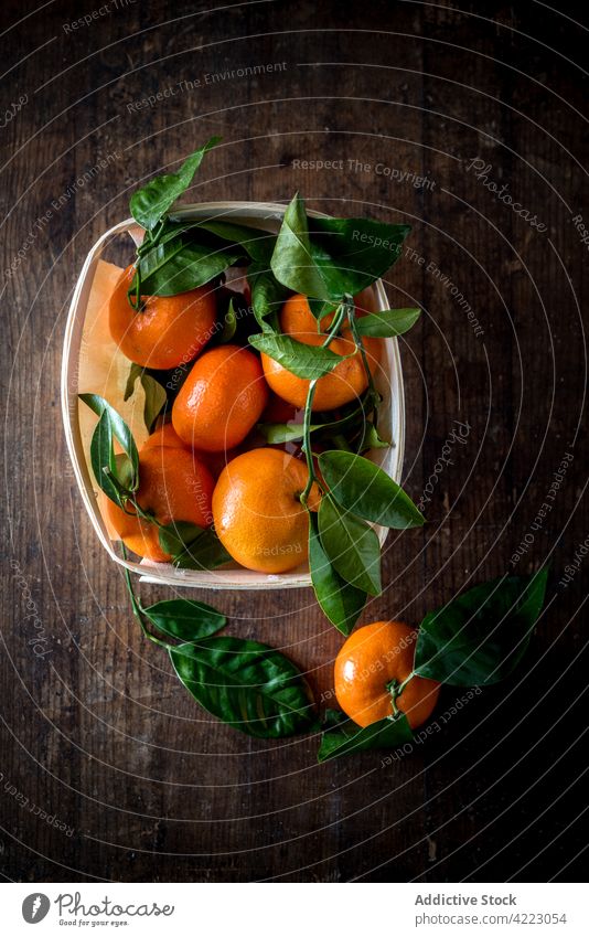 Whole ripe mandarins with leaves in container fruit citrus fresh vitamin tropical exotic natural leaf bright organic orange green color unpeeled colorful
