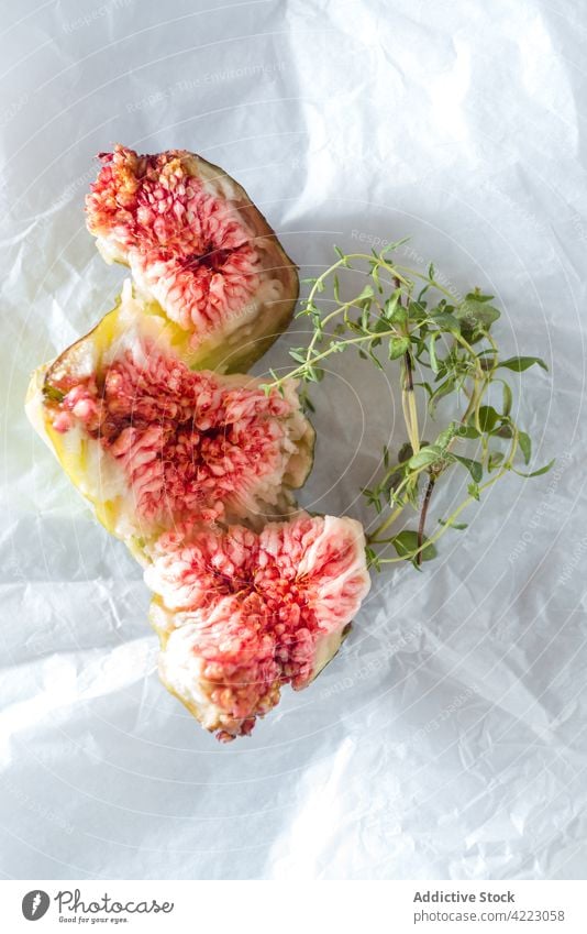 Ripe fig slices with fresh thyme sprigs on white background fruit herb juicy healthy food sweet tasty vitamin natural ripe pulp leaf cut organic piece