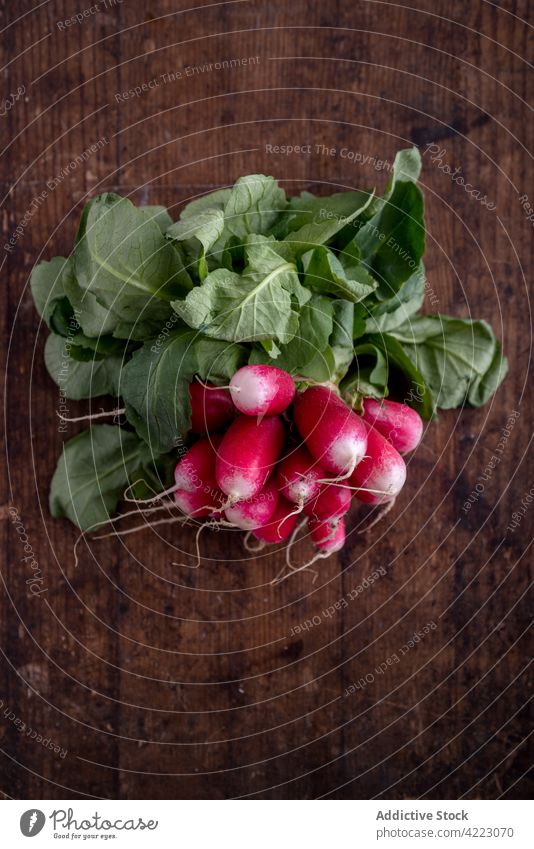 Pile of fresh radish with wavy foliage on wooden surface vegetable healthy food nutrient vitamin product organic pile rustic style root vegan curve ripe natural