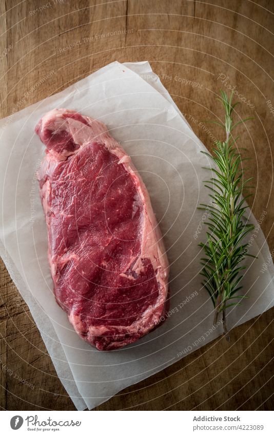 Raw beef steak with fresh rosemary sprigs meat herb recipe natural product ingredient culinary protein uncooked aromatic vegetable sheet piece assorted