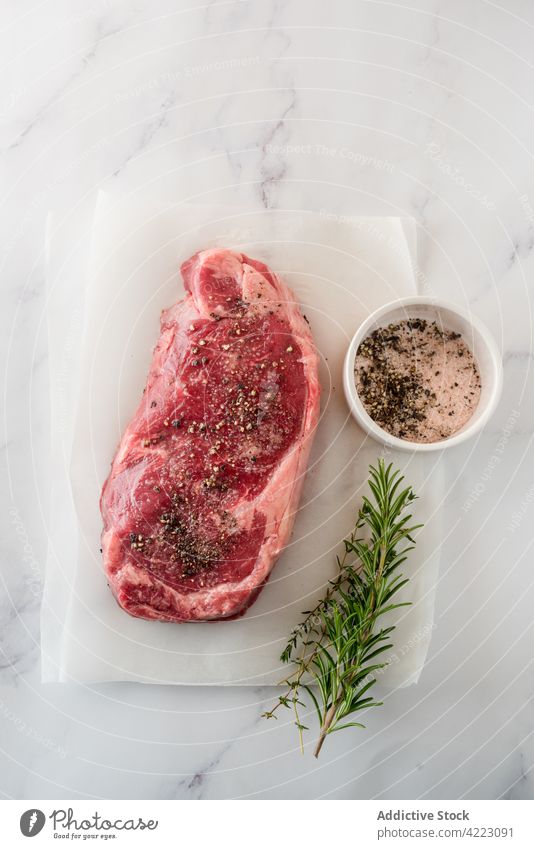 Raw beef steak with fresh rosemary and thyme sprigs meat herb recipe natural product ingredient culinary protein uncooked aromatic vegetable sheet piece