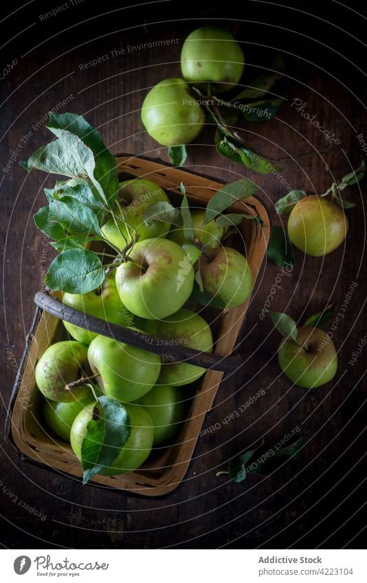Fresh apples with foliage in basket on brown background fruit healthy food natural ripe fresh organic leaf heap handle harvest ingredient edible product whole