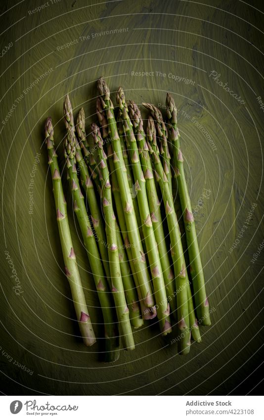 Pile of fresh asparagus stems on green background vegetable raw natural healthy food organic vegetarian ingredient pile vitamin color heap edge identical edible