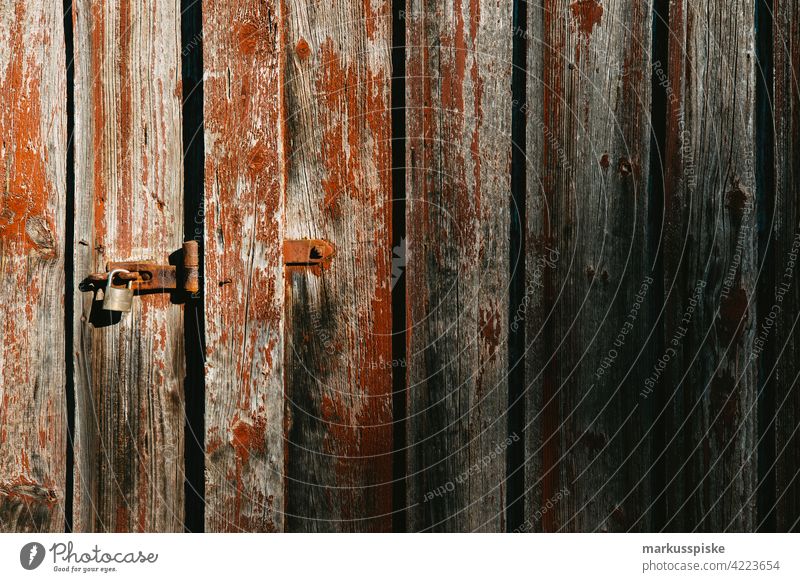 Barn door locked Barn Door Lock closed door Padlock peeled off flaking paint Wooden gate Weathered weathered wood weathering Old Decline Derelict