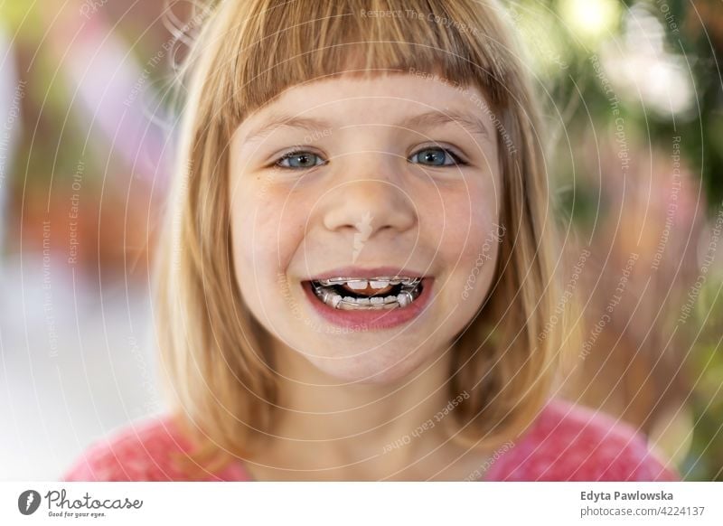 Portrait of a smiling little girl with braces toothy teeth dental dentist hygiene care child portrait smile happy young cute face childhood kid beautiful beauty
