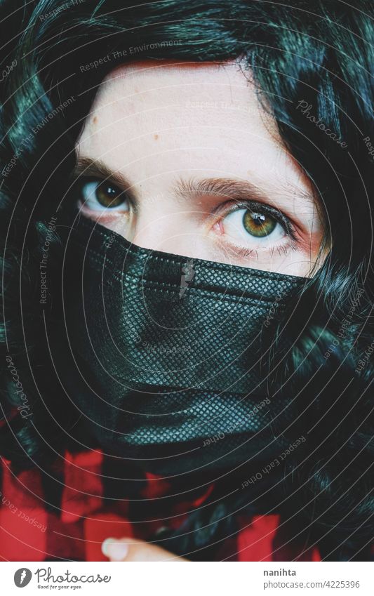 Young woman wearing a black face mask covid coronavirus influenza plaid hirt close up look green eyes white caucasian health health care medical curly