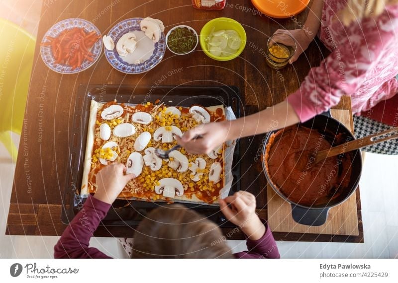 Children preparing pizza at home learning quality time spending time with family together kids childhood preparation food cheerful smiling girl people table