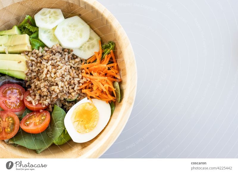 Brown rice salad with carrot, egg, cucumber, avocado, tomato and lamb's lettuce above antioxidant asian background bowl brown buddha bowl copy space cuisine
