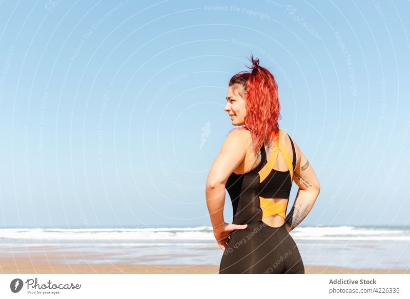 Self confident sportswoman with tattoos on sea coast self assured satisfied sporty individuality contemplate seashore portrait athlete self confident