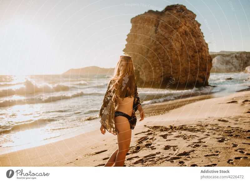 Unrecognizable fit woman in swimsuit standing on sandy beach chill seashore rock resort paradise slim sunbath nature fyriplaka milos greece seaside tranquil