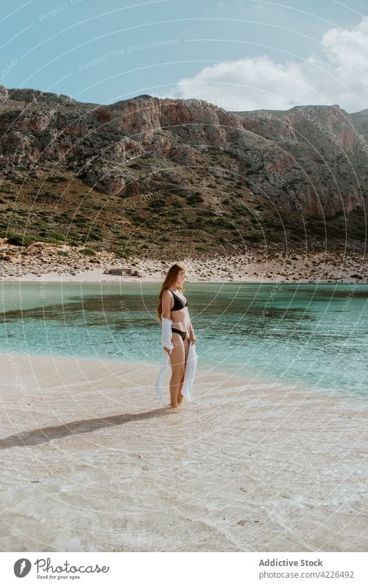 Attractive woman in swimwear standing on sandy seashore chill balos beach swimsuit rock resort paradise picturesque suntan rest bikini crete slim sunbath nature