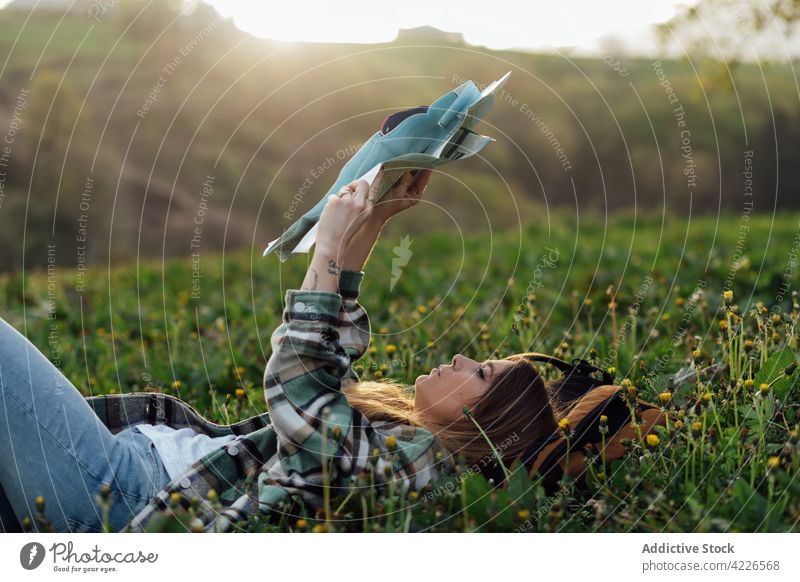 Tourist with map resting in field traveler focus vacation countryside woman nature mountain trip tourist journey paper guide orientate navigate route