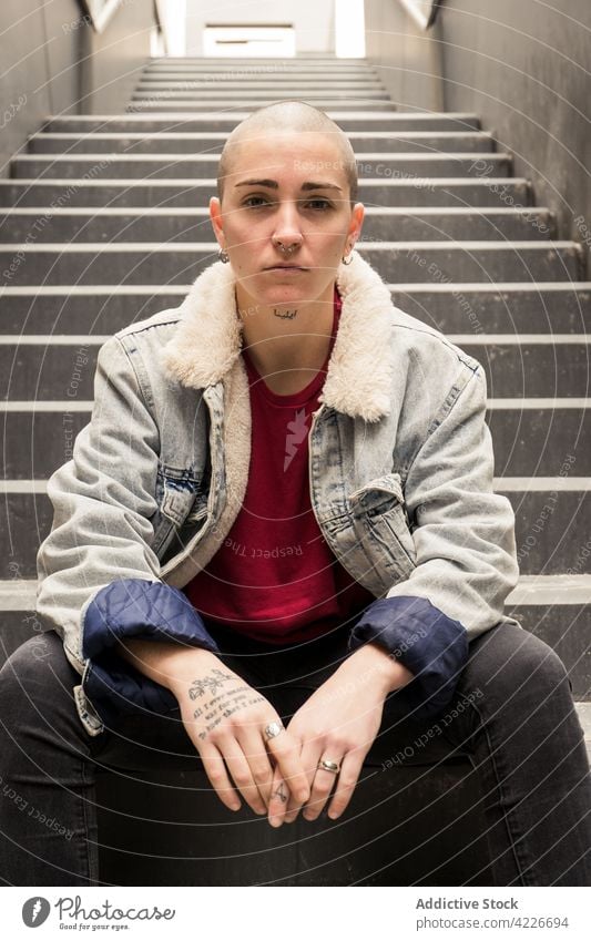 Queer with clasped hands resting on stairs queer hands clasped individuality cool street style accept identity gender portrait transgender androgynous