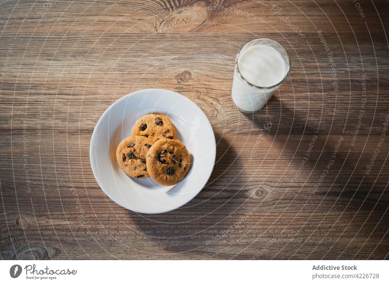 Milk and delicious oat cookies for breakfast milk sweet treat dairy chocolate chip nutrient table plate oatmeal baked biscuit transparent domestic desk wooden
