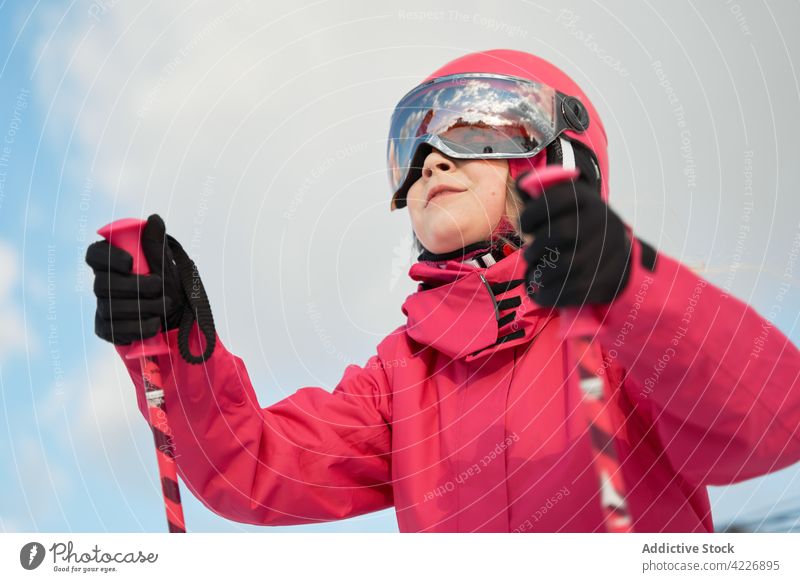 Content girl in helmet skiing on snowy slope activity activewear sport hobby vitality energy winter development physical positive skill goggles sporty
