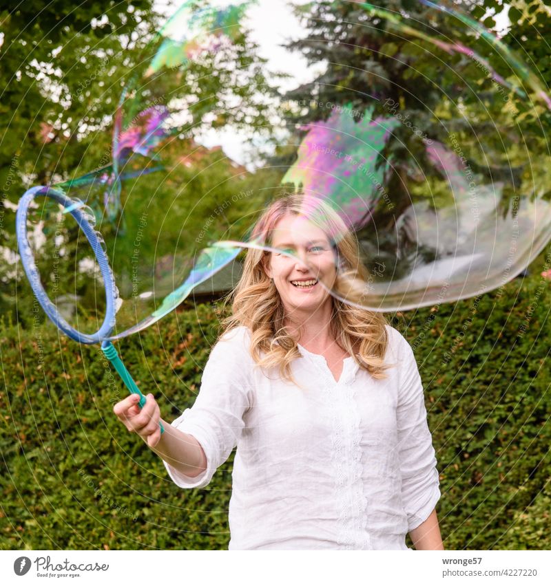 Magic of soap bubbles magic Young woman Gimmick Playful fun Comical muck about Happiness Exterior shot Summer Colour photo Giant bubble