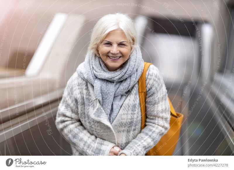 Happy Senior Woman On Escalator glasses eyeglasses happy smiling enjoying relaxed positivity confident natural senior seniors pensioner pensioners woman casual