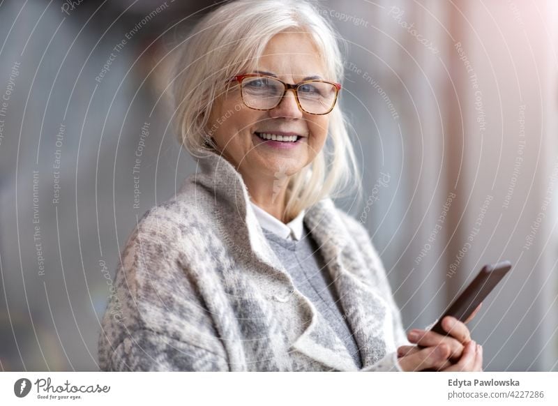 Portrait of senior woman using mobile phone glasses eyeglasses happy smiling enjoying relaxed positivity confident natural seniors pensioner pensioners casual