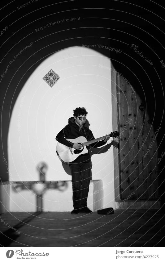 young singer with an accustical guitar at the door of a church. performer guitarist lessons caucasian spiritual music instrument musician lifestyle man people