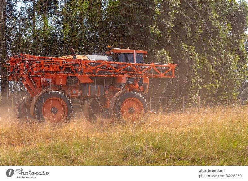 Agricultural sprayer moving on a dirt road agricultural agriculture agronomy cereal countryside crop cultivate cultivated driving equipment evening farm farmer