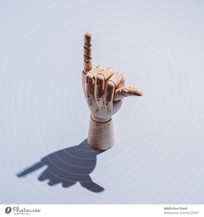Wooden hand showing hang loose gesture placed on white surface shaka sign decor design decoration mannequin flexible concept wooden symbol creative culture