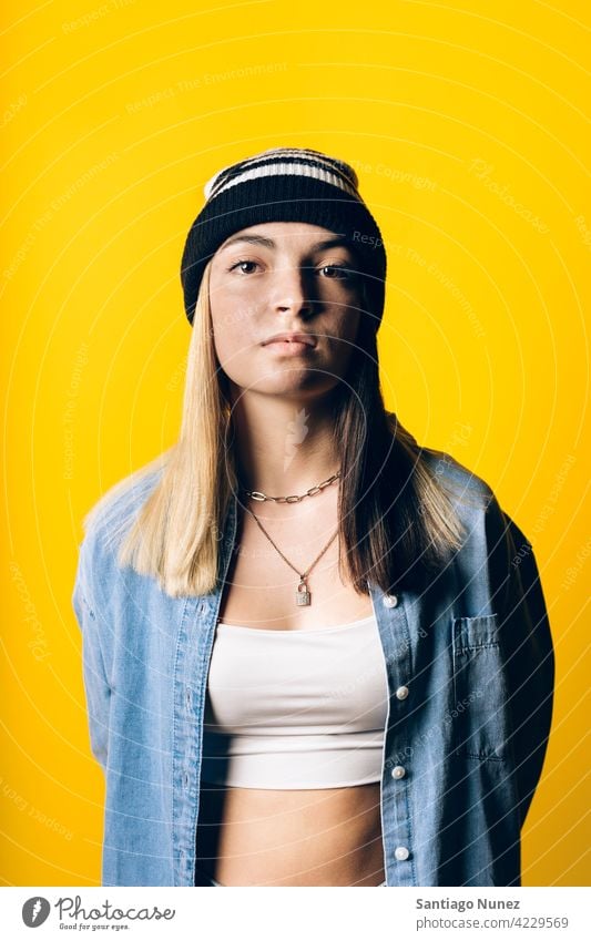 Girl Wearing Hat Portrait studio yellow background portrait looking at camera expression colorful hair style casual young girl female serious two colors hair
